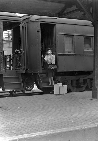 Woman on steps of railroad car. Part of Manchester's department store "Back to School."