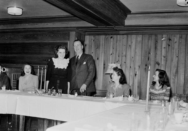 Roundy Coughlin standing with a woman behind the head table at a Press Club Dinner at Edgewood College.