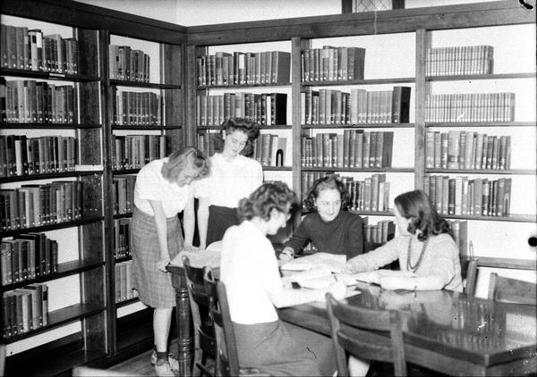 Five Edgewood students studying around a table in the library.