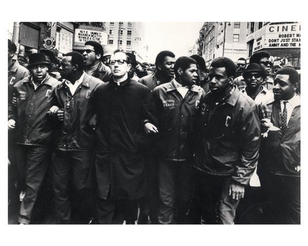 Father James Groppi (1931-) and social activists at NAACP March, marching east up Wisconsin Avenue.