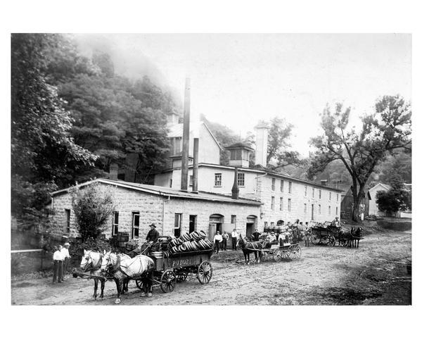 Brewery wagons loaded with beer barrels in foreground of the Potosi Brewery.