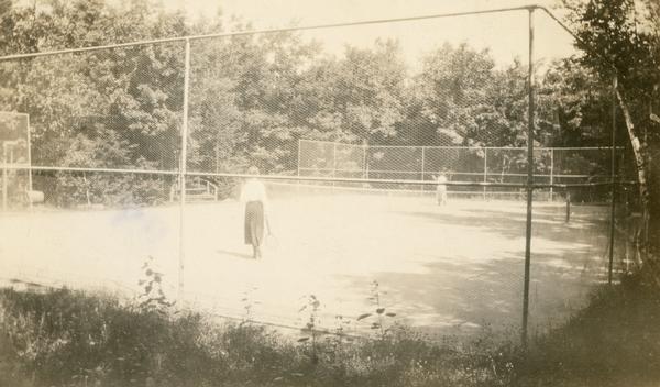 Two women playing tennis at Coole Park Manor on Madeline Island.