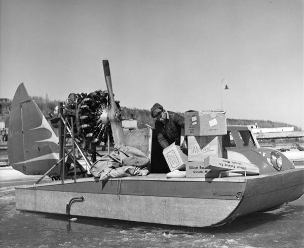 Elmer Nelson sorting through boxes of goods being transported on the "Dream Sled" windsled.