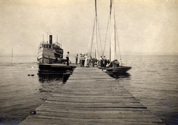 Steamboat "Skater" and two sailboats at end of the mission dock on Madeline Island.