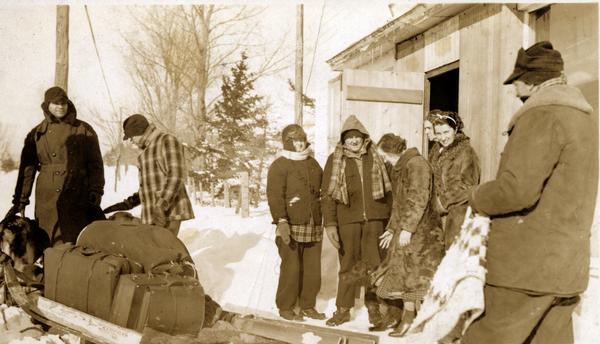 Dog sled loaded with luggage. Identified from left: first two unidentified; Mary Louise O'Brien Eldridge; Richard Eldridge; Margaret Russell; Gram Johnson (face only); Ellen Russell; Howard Russell.