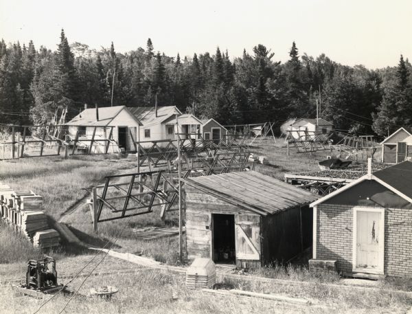 Elevated view of land operations of commercial fishing operation with fish net drying reels and buildings on Apostle Islands.