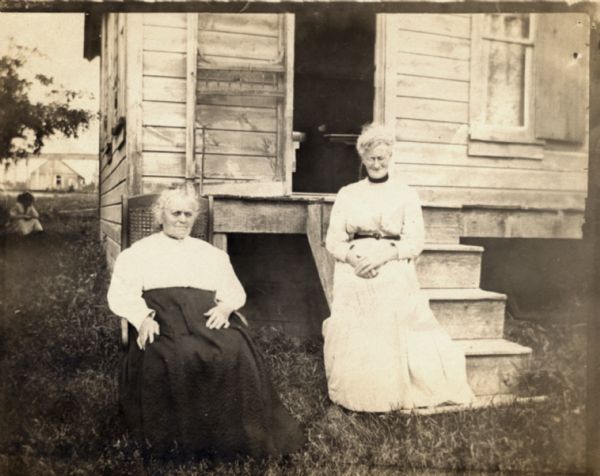 Mrs. Elizabeth Lathrop sitting on steps of La Point Post Office with an unidentified woman.