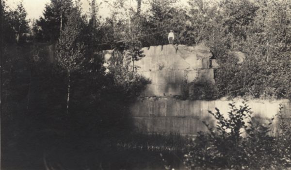 Bill Baker standing on top of a wall of the quarry on Basswood Island.