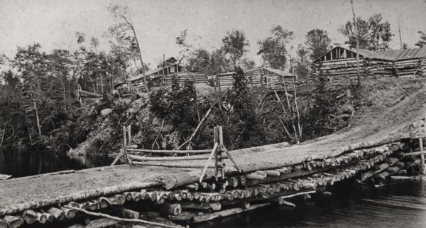 Logging Camp dock and buildings made of logs. Madeline Island shoreline on the bank of Lake Superior.