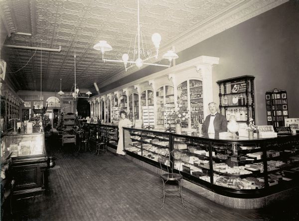 Mr. Sumner stands behind his drugstore's well-stocked candy counters.