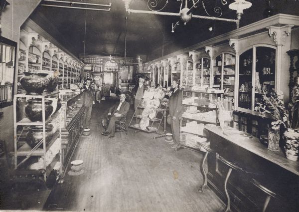Interior view of Sumner's Drugstore, which was established in 1855. From left to right are George "Jud" Stone, Edwin Sumner, and Bert B. Collyer.