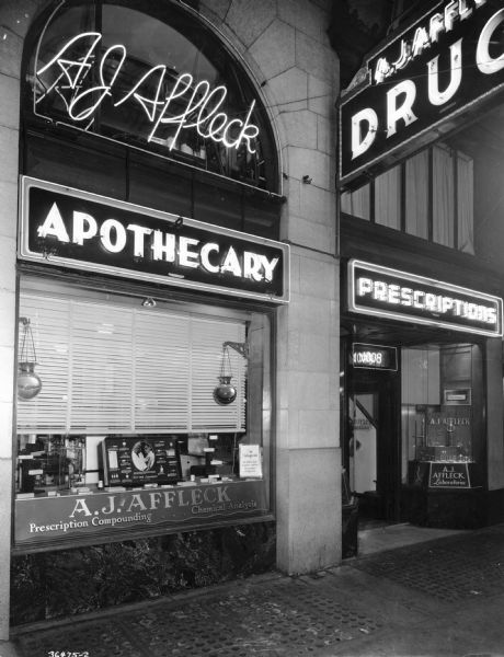 Modern neon sign and storefront of A.J. Affleck's Pharmacy.