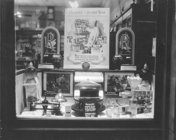 Eye-catching National Pharmacy Week window display at J.W. Hart's Pharmacy, show-casing the many ways in which pharmaceutical innovations were helping to win the war.