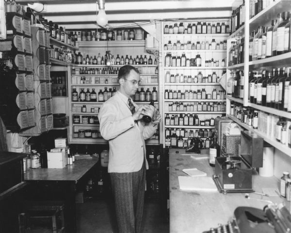 Roy Bird Cook mixes liquid medications in his pharmacy's laboratory.