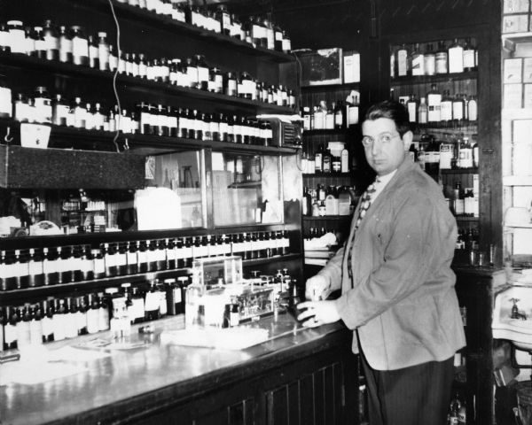 Druggist J.R. De Philip, proprietor of Hieber's Drugstore, pauses while preparing a prescription in the dispensary.