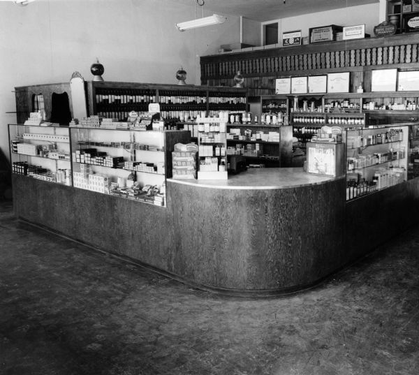 View of the curved wooden prescription pick-up counter at Kelly's Prescription Shop.