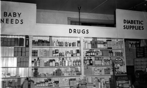A display of various drugs and supplies at Tesiero's Pharmacy. Items for "Baby Needs" and "Diabetic Supplies" are located at either end.