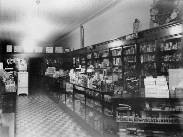 View of the east side of Judisch Brothers' Drug Company store room. The "Sundries" section of the counter is towards the front; the "Prescriptions" to the rear.