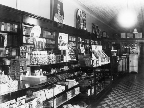 View of Judisch Pharmacy's candy counter, located on the west side of the store. A large Whitman's Chocolates advertisement is on the wall.