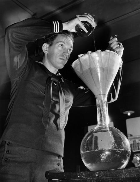 A Pharmacist Mate-in-Training from the U.S. Coast Guard Hospital Corps School filters a liquid for a test prescription. This filtration process helped to eliminate particles of solids or other impurities.