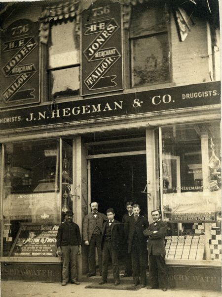 William Bryan, J.B. Glenny, 3 assistants, and J.W. Ferris on the doorstep of the J.N. Hegeman & Company Drugstore.