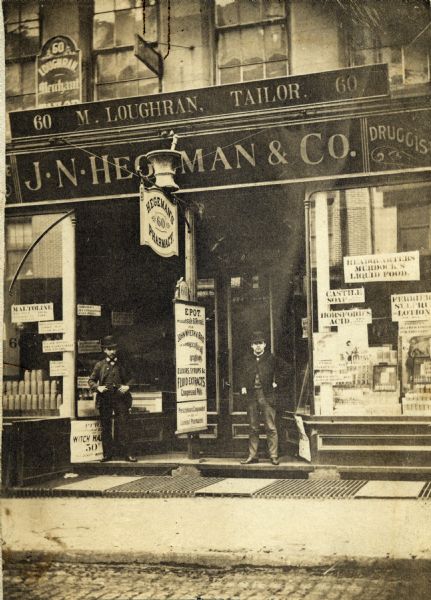 Several employees on the doorstep of J.N. Hegeman Drugstore.
