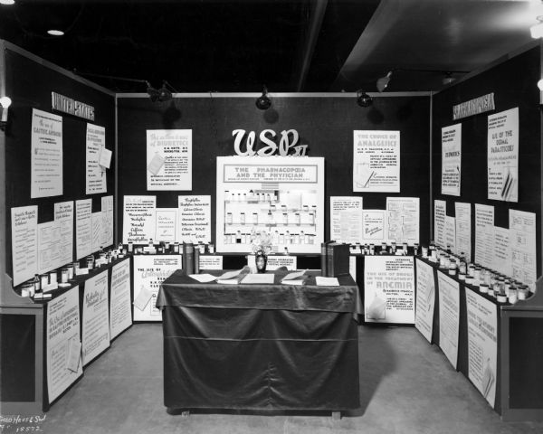 View of a U.S. Pharmacopeia exhibit titled: "The Pharmacopeia and the Physician", at the American Medical Association conference. The informational display discusses the USP's central role in the regulation of drugs and their relationship with physicians.