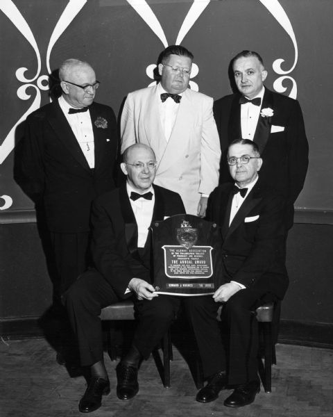 Dr. Robert Fischelis (seated, left), and Dr. Edward Hughes pose with an annual Alumni Association award plaque. Standing (L to R), College President Griffith, Awards Chairman McDonnell, and Alumni President Merrick look on.