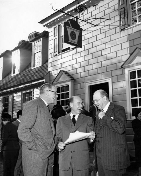 Pictured are (L to R):  Kenneth Chorly (Pres. of Colonial Williamsburg), Dr. Tom D. Rowe (Chair of National Pharmacy Week), and Robert P. Fischelis (Secretary of American Pharmaceutical Association). They are standing outside the Pasteur Galt Apothecary Shop in Colonial Williamsburg, discussing the proclamation for National Pharmacy Week, following opening ceremonies.