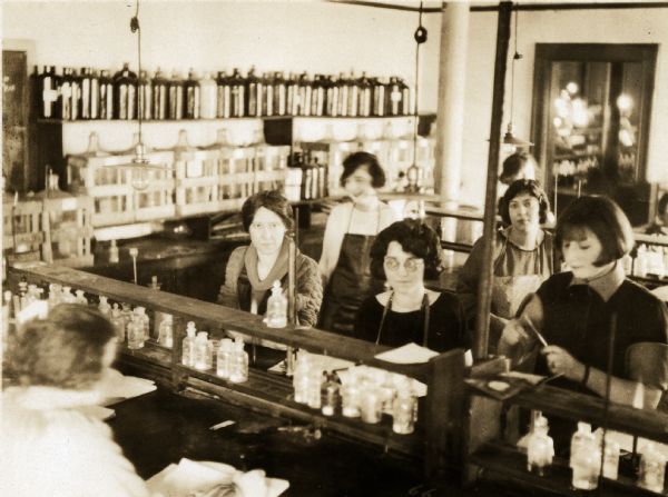 View of several female students in a pharmacy laboratory class. Included are A. Herman, L.E. McDermott, N. Evans, and Dottie.
