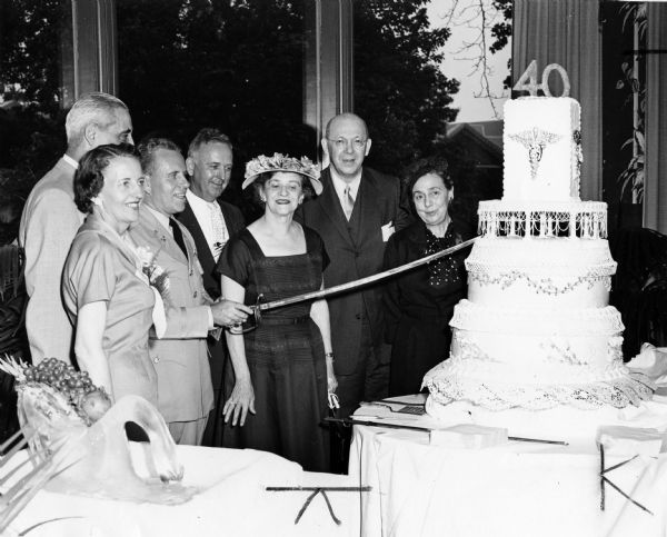 Army Signal Service Corps cuts cake to honor its 40th birthday. The corps consisted of about 4,100 members of whom 300 to 400 are pharmacists in commissioned officer status. Pictured are, left to right: Mrs. Bernard Aabel, George H. Frates (Washington Representative, National Assoc. of Retail Druggists), Col. Bernard Aabel (MSC Chief), Col. Dale Thompson (Executive Officer, Walter Reed Army Medical Center), Mrs. Frates, Dr. Robert Fischelis (secretary-manager, American Pharmaceutical Association), Mrs. Fischelis.