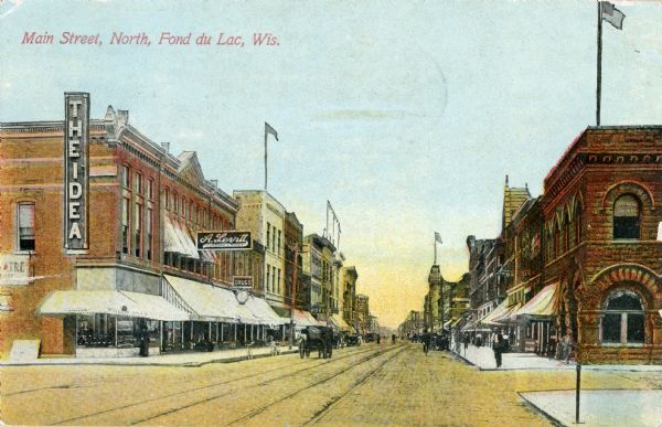 View of various businesses located on north Main Street, including A. Levitt Clothing Store, The Idea, and two drugstores. Caption reads: "Main Street, North, Fond du Lac, Wis."