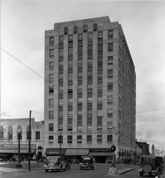 View of the front face of the Tenney Building, corner of Pinckney and Main Streets, on the Capitol Square. Liggetts Drug Store occupies a portion of the lowest level. The majority of the building was occupied by insurance companies.