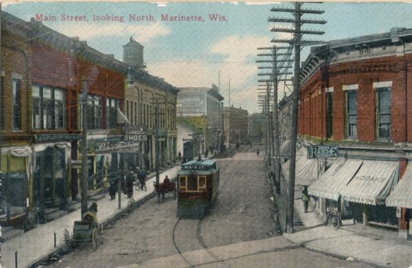 Elevated view of a streetcar going down North Main Street. Raiche Drugstore sits on the right corner.