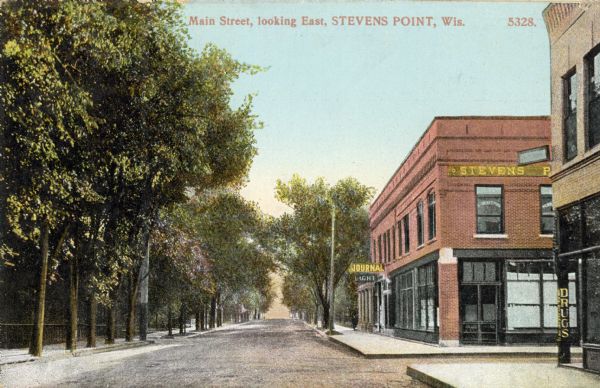 View of Main Street, looking eastward. A drugstore and the Stevens Point Journal offices are on the right. Caption reads: "Main Street, looking East, Stevens Point, Wis." Trees line the sidewalk on the left.