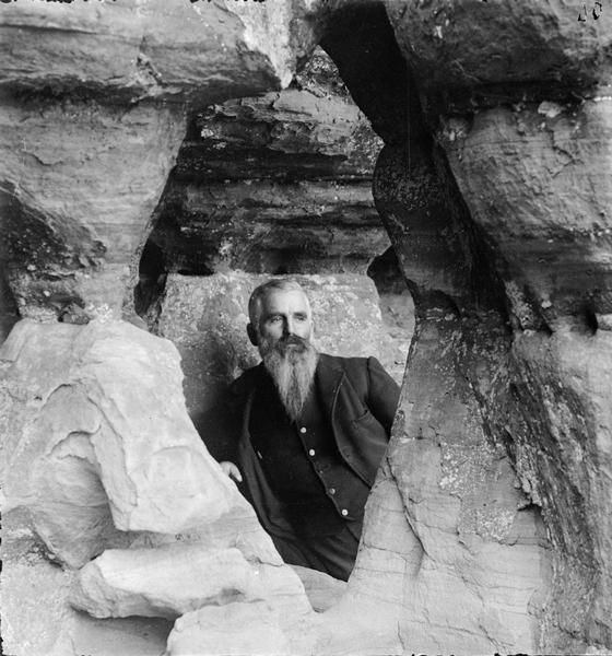Hermit of Diamond Grotto (probably William H. Metcalf) looking through Black Hawk's Port Hole, Diamond Grotto.