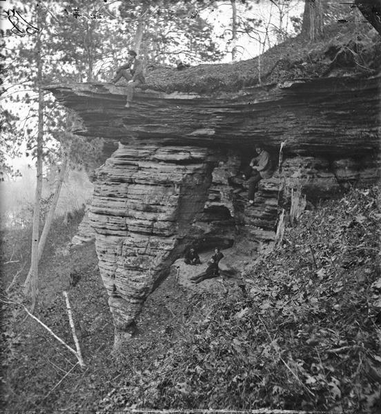 West side of Hornet's Nest. One man sitting on top edge, one sitting at right under overhang, three in background below overhang.
