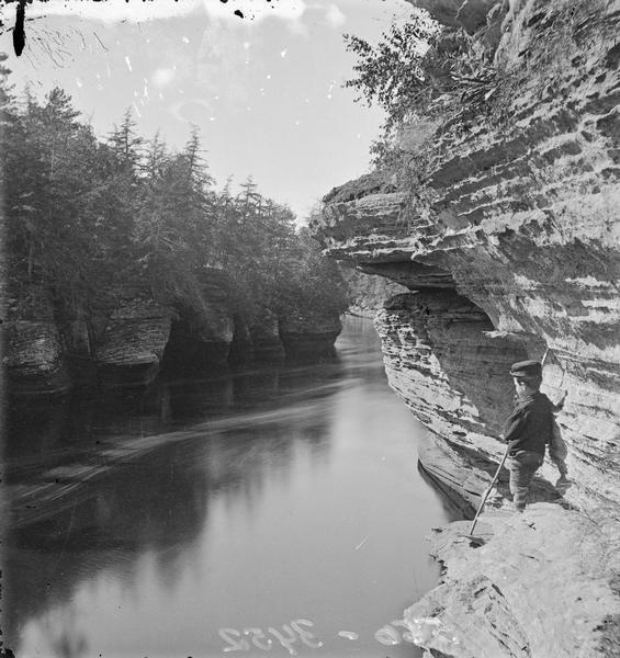 Navy Yard, looking downstream from Sturgeon Rock. On the right is a boy with a pole standing on rocks.