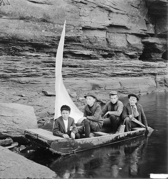 Ashley Bennett and three friends in a homemade sailboat. This was captioned: "Going to Join the Navy."