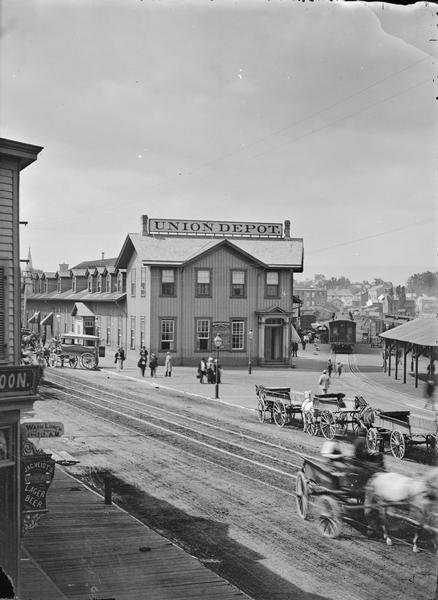 Elevated view across street towards the Union Depot. Horse-drawn carriages are in the street.