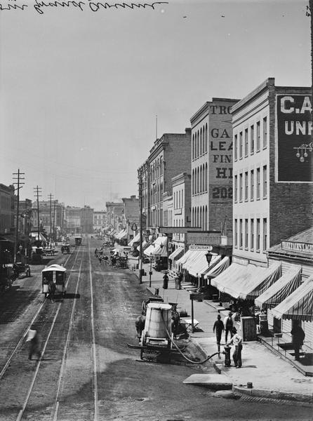View up West Water Street from Grand Avenue with street cars.