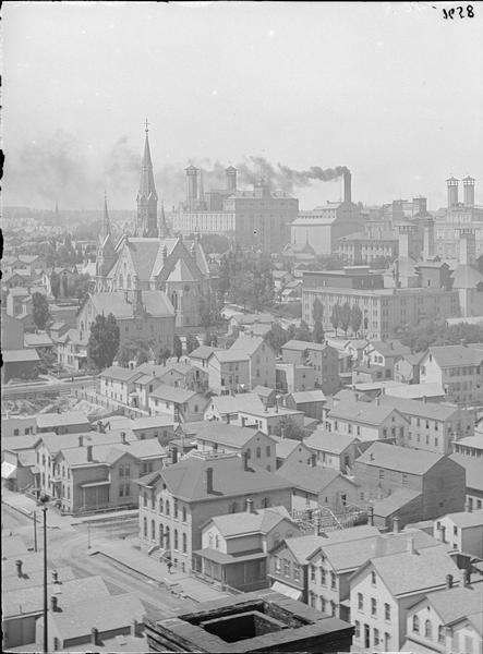 View northwest from Exposition Building. Buildings, church, and smokestack in background.