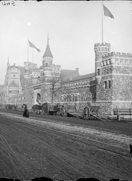 Libby Prison at the Columbian Exposition. Several carts, horses in front of the building.