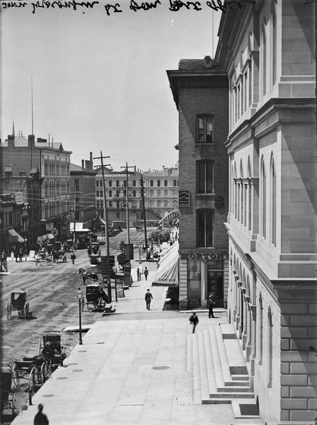 Elevated view from the Post Office of Wisconsin Avenue, with buildings and street traffic.