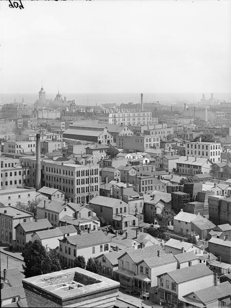View east of buildings and lake from the dome of the Exposition building. Lumber is stacked on the right.