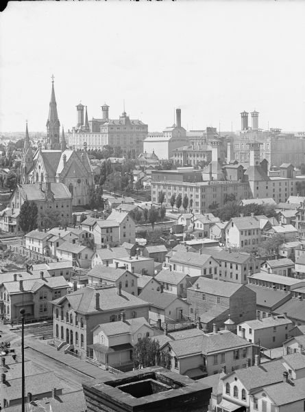 View of buildings from the dome of the Exposition building, including a church and the Best Brewing Company in the distance.