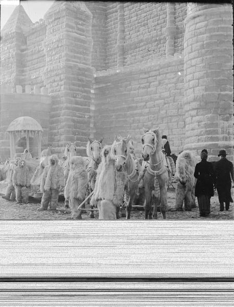 St. Paul Ice Carnival. Men in white fur suits are standing in front of ice palace with horses.