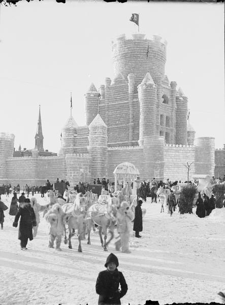 St. Paul Ice Carnival. Royal family leaving ice palace in their equipage. Crowds are milling about.