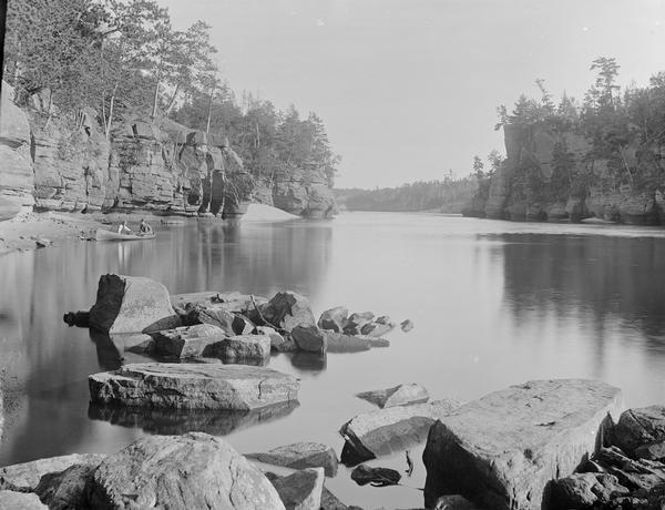 Lower Jaws from Stone Pile. Two men are in a canoe near the shore at left.