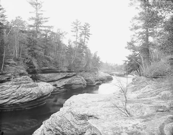 View of Narrows from Black Hawk's Leap. Graffiti on rocks reads: "Leroy Gates, Dells River Pilot 1849 to 1858."